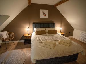 - une chambre mansardée avec un grand lit dans l'établissement Tyn Llwyn Barn, à Corwen