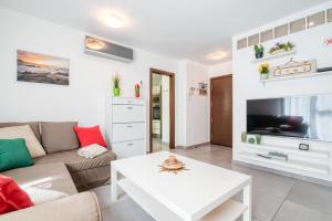 ein Wohnzimmer mit einem Sofa und einem Tisch in der Unterkunft Mare Home - Beach & City in Las Palmas de Gran Canaria