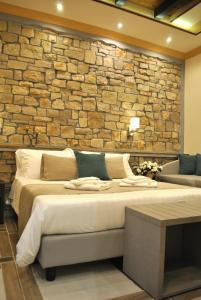 a bedroom with two beds and a brick wall at Antica Piacenza in Piacenza