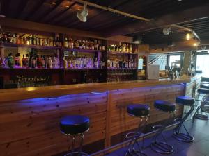 a bar with blue stools in front of a wooden counter at Norwide - Hossan Lomakeskus in Hossa