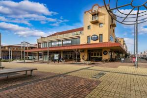 a building on a street with a bench in front at Tuggeranong Short Stay #10 - Sleeps 6 in Tuggeranong