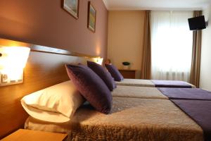 a hotel room with two beds and a window at PENSIÓN RÚA in Arzúa