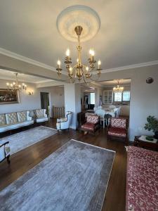 a living room with a chandelier and a table and chairs at 10 minutes to Trabzon city Full view special villa in Kisarna