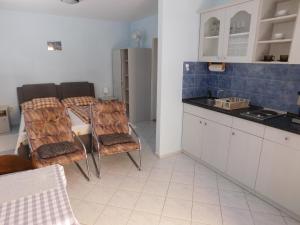 cocina con 2 sillas, mesa y fregadero en Akácfa Hortenzia Apartman en Zalakaros