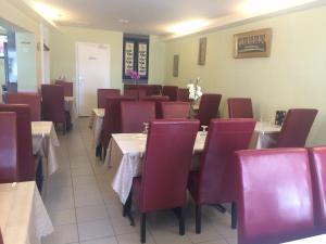 une salle à manger avec des tables et des chaises rouges dans l'établissement Hotel Restaurant Tokyo, à Trouville-sur-Mer