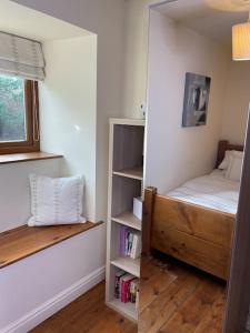 a bedroom with a bed and a book shelf at Daisy Cottage in Keighley