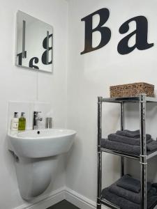a bathroom with a sink and a toilet and a mirror at Daisy Cottage in Keighley +11 photos