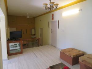 an empty living room with a tv and a couch at NISARGA in Yercaud