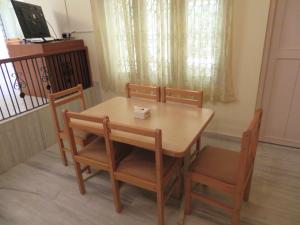 a dining room table with two chairs and a wooden table and chairsuggest at NISARGA in Yercaud