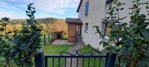 a fence in front of a house with a door at Le Cocon Beaujolais in Châtillon