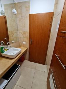 a bathroom with a sink and a wooden door at Fantastic - C19 Room B in Warsaw