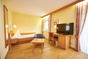 a hotel room with a bed and a television at Gasthof-Hotel Zur Post Samerberg in Törwang