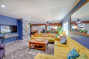 a living room with yellow couches and a tv at Payson Vacation Rental with Private Patio! in Payson