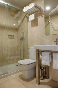 a bathroom with a shower and a toilet and a sink at Hotel Oslo in Coimbra