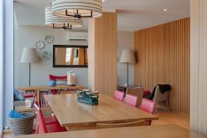a dining room with a table and pink chairs at Hotel Oslo in Coimbra