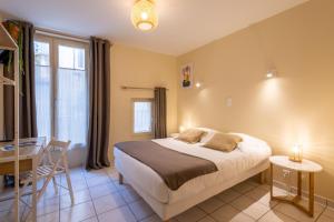 Postel nebo postele na pokoji v ubytování L'Aptois Hôtel