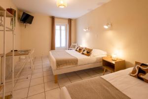 Postel nebo postele na pokoji v ubytování L'Aptois Hôtel