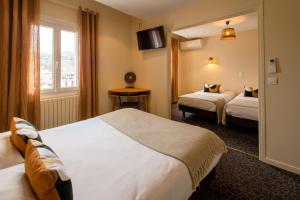 Postel nebo postele na pokoji v ubytování L'Aptois Hôtel