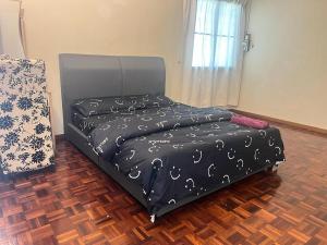 a bedroom with a bed with a black comforter at Batu Pahat Airbnb Homestay Empire 9 in Batu Pahat