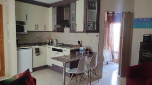 a kitchen with white cabinets and a table and chairs at apartemento rural in Lumpiaque