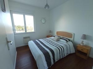 sypialnia z łóżkiem z paskiem i oknem w obiekcie Gîte La Mer, 50m de la mer w mieście Saint-Germain-sur-Ay