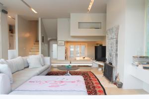 a living room with a white couch and a fireplace at The Architect's Crib in Porto Heli