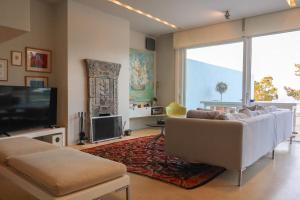 a living room with a couch and a flat screen tv at The Architect's Crib in Porto Heli
