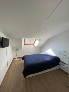 1 dormitorio con 1 cama azul en el ático en Apartamento Almogaren, en Valsequillo