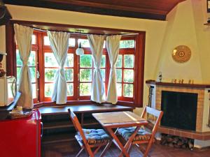 a living room with a table and a fireplace at Hospedagem Spa da Alma in Monte Verde