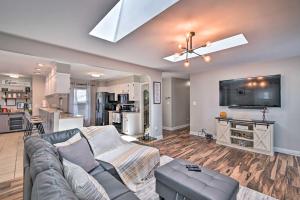 a living room with a couch and a flat screen tv at Fayetteville Vacation Rental with Sunroom and Yard! in Fort Bragg