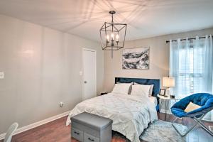 ein Schlafzimmer mit einem Bett und einem blauen Stuhl in der Unterkunft Fayetteville Vacation Rental with Sunroom and Yard! in Fort Bragg