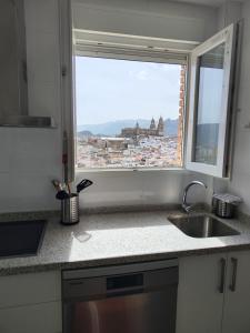 a kitchen with a sink and a window with a view at ENTREOLIVOS in Jaén