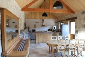 eine Küche mit Holzdecken sowie einem Tisch und Stühlen in der Unterkunft Oltarcie - Maison d'hôte avec piscine in Espagnac-Sainte-Eulalie