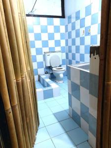 a blue and white bathroom with a toilet and a tub at Bella's Beach Resort Apartment 8 in Bauang