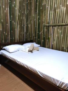 ein Bett mit einem Buch und einem Telefon darauf in der Unterkunft Bella's Beach Resort Apartment 8 in Bauang