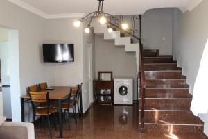 - un salon avec une table à manger et des escaliers dans l'établissement Дом на пляже Black sea House, à Kobuleti