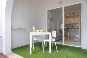 una mesa blanca y sillas en la sala de estar. en Naia House Lanzarote, en Puerto del Carmen