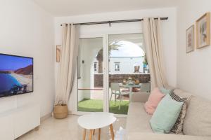 sala de estar con sofá y vistas al océano en Naia House Lanzarote, en Puerto del Carmen