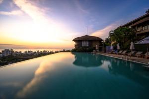 カロンビーチにあるKaron Phunaka Resortの夕日を背景に見えるスイミングプール