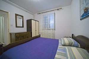 a bedroom with a large purple bed with a window at Apartment Renata in Postira