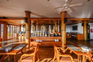 カロンビーチにあるKaron Phunaka Resortの木製のテーブルと椅子のあるレストラン、バー