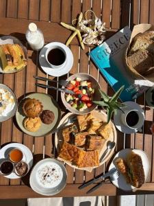 a table with many plates of food and coffee at Sivotahomes-blu in Sivota
