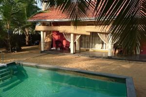 una casa con piscina frente a una casa en Nayan's Paradise en Kottanitivu