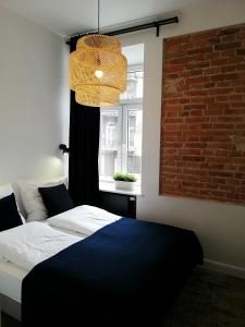 a bedroom with a bed and a window at Rooms by Apartamenty Lubartowska Street in Lublin