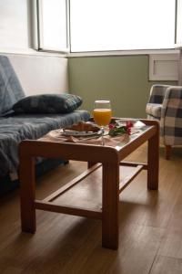 a coffee table in a living room with a glass of orange juice at Hotel Leyton in Foz