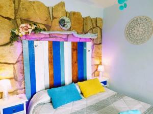 a bedroom with a bed with a rock wall at AlmenaraLove Bellaluna in Robledo de Chavela
