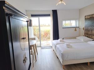 a hotel room with two beds and a window at Seehotel Oostkapelle in Oostkapelle