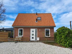 ein kleines Backsteinhaus mit orangefarbenem Dach in der Unterkunft Seehotel Oostkapelle in Oostkapelle