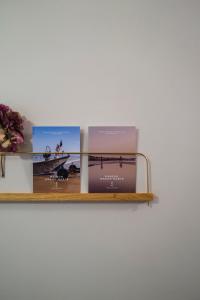 three books on a shelf on a wall at Maison Grand Sable in Veules-les-Roses