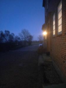 światło na boku budynku ceglanego w nocy w obiekcie Bed & Kitchen „Den gamle Skole“ Nr. Sejerslev w mieście Højer